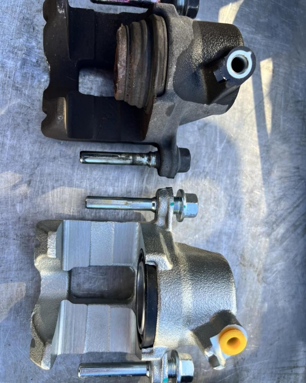 Two Brake Calipers Are Sitting Next To Each Other On A Table — Weyba Automotive Services In Maroochydore, QLD