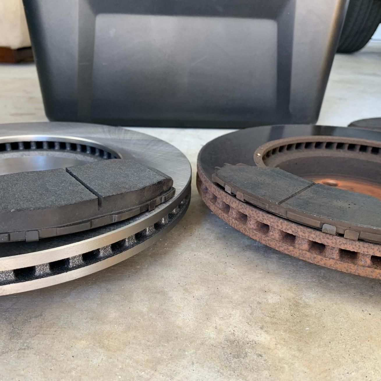 Two Brake Rotors Are Sitting Next To Each Other On A Concrete Surface — Weyba Automotive Services In Kuluin, QLD