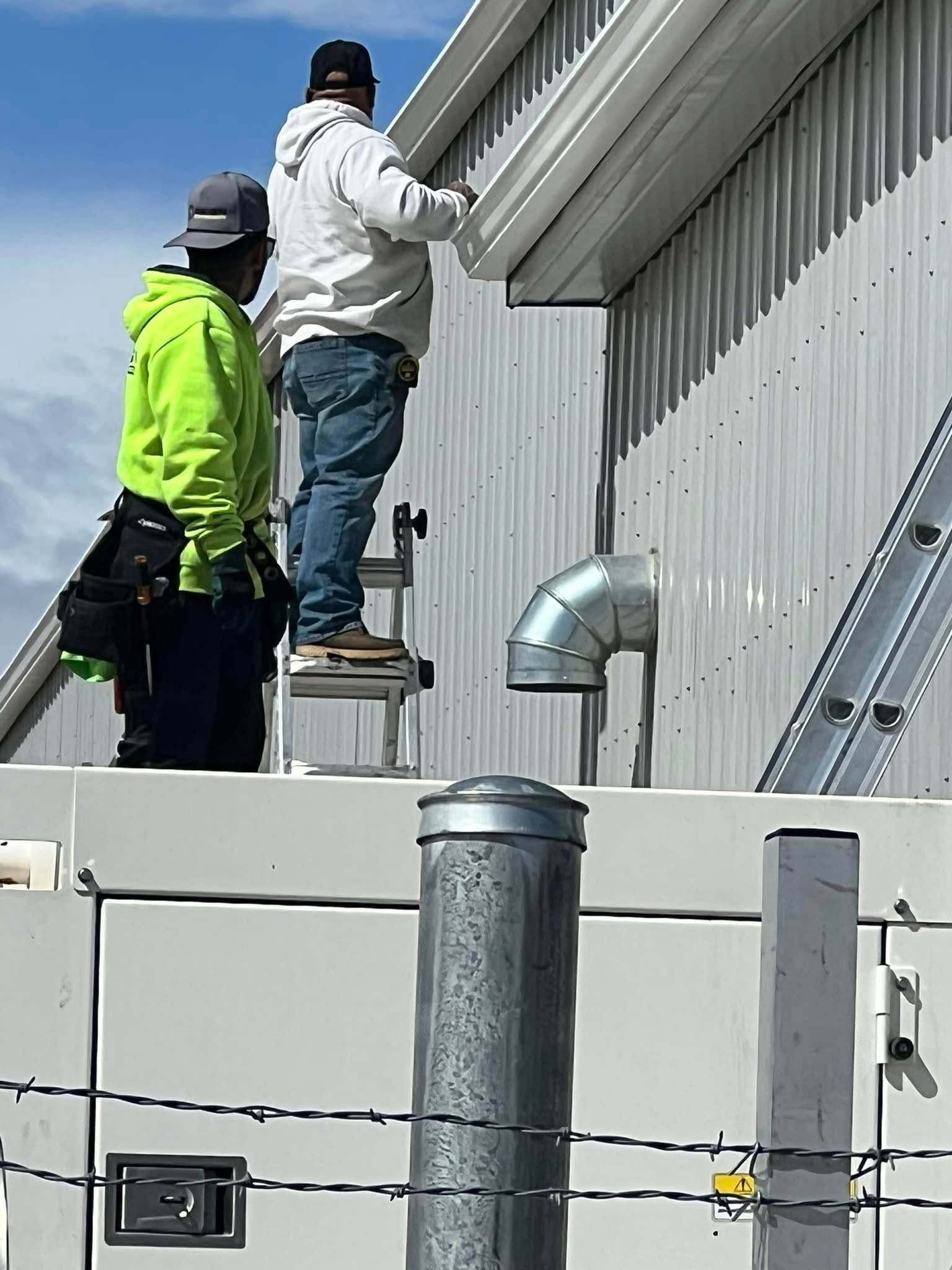 Two men are working on the roof of a building.
