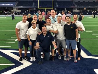 A group of people are posing for a picture on a football field.