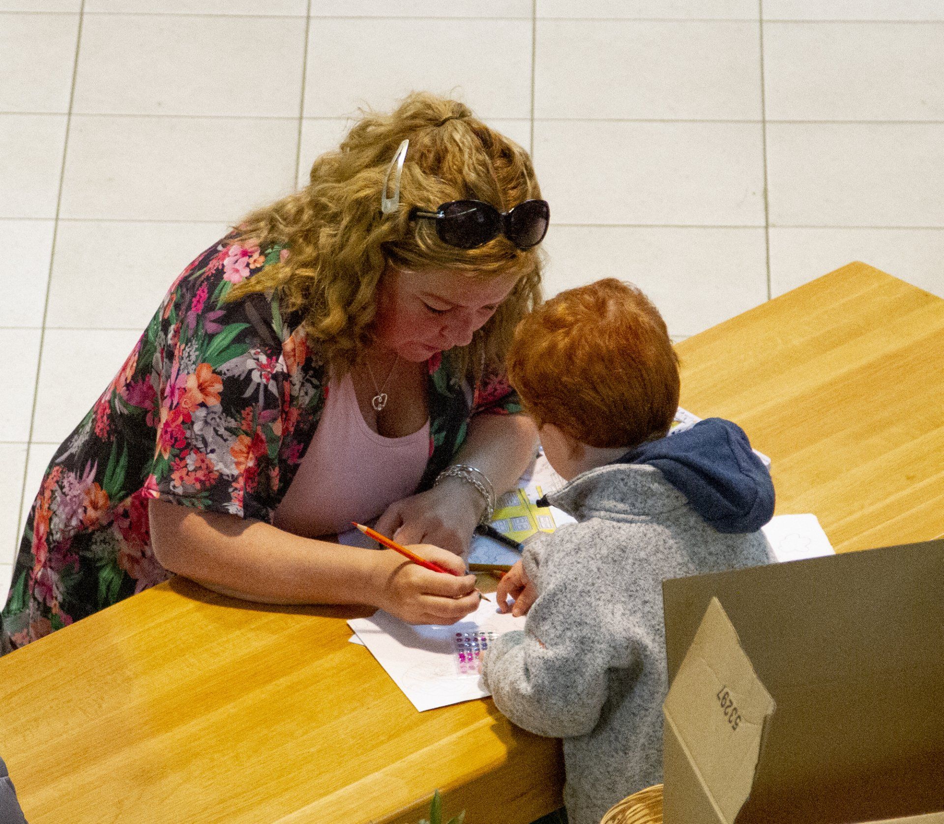 A woman is helping a young boy with his homework