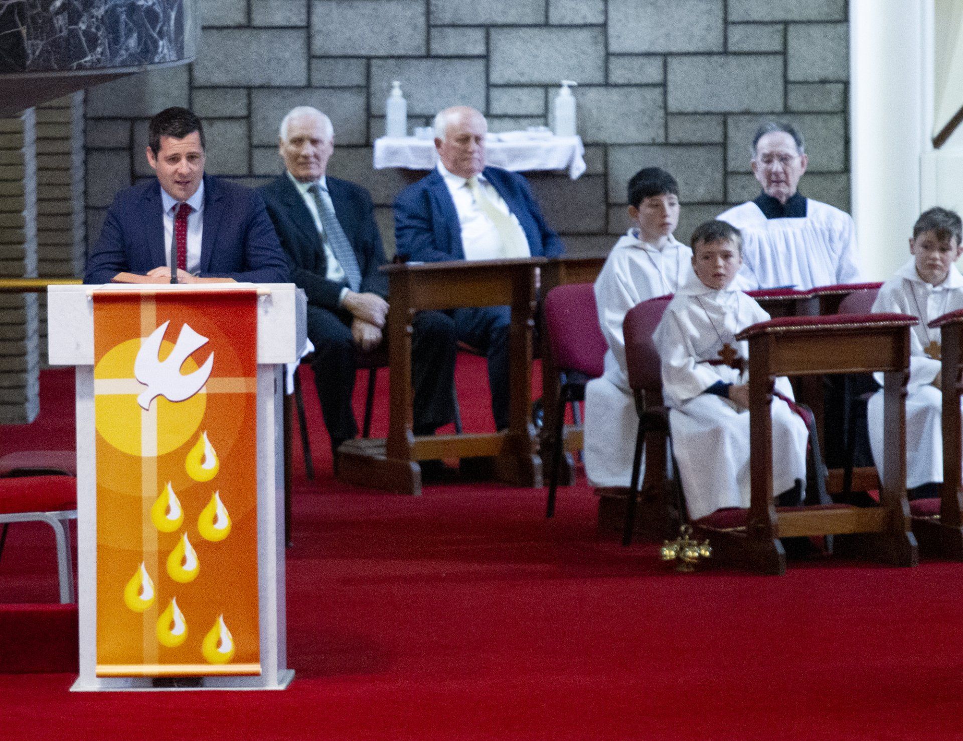 A group of people are sitting around a podium in a church.