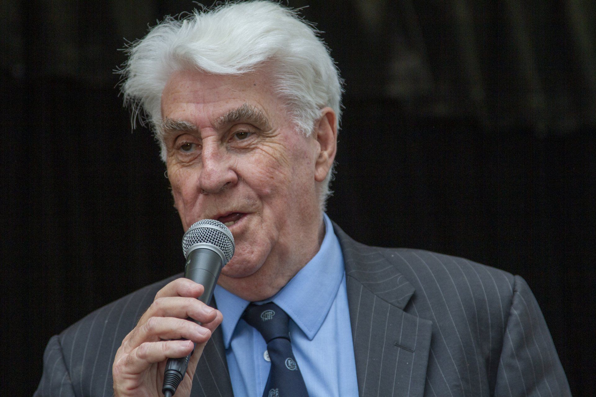 A man in a suit and tie is singing into a microphone.
