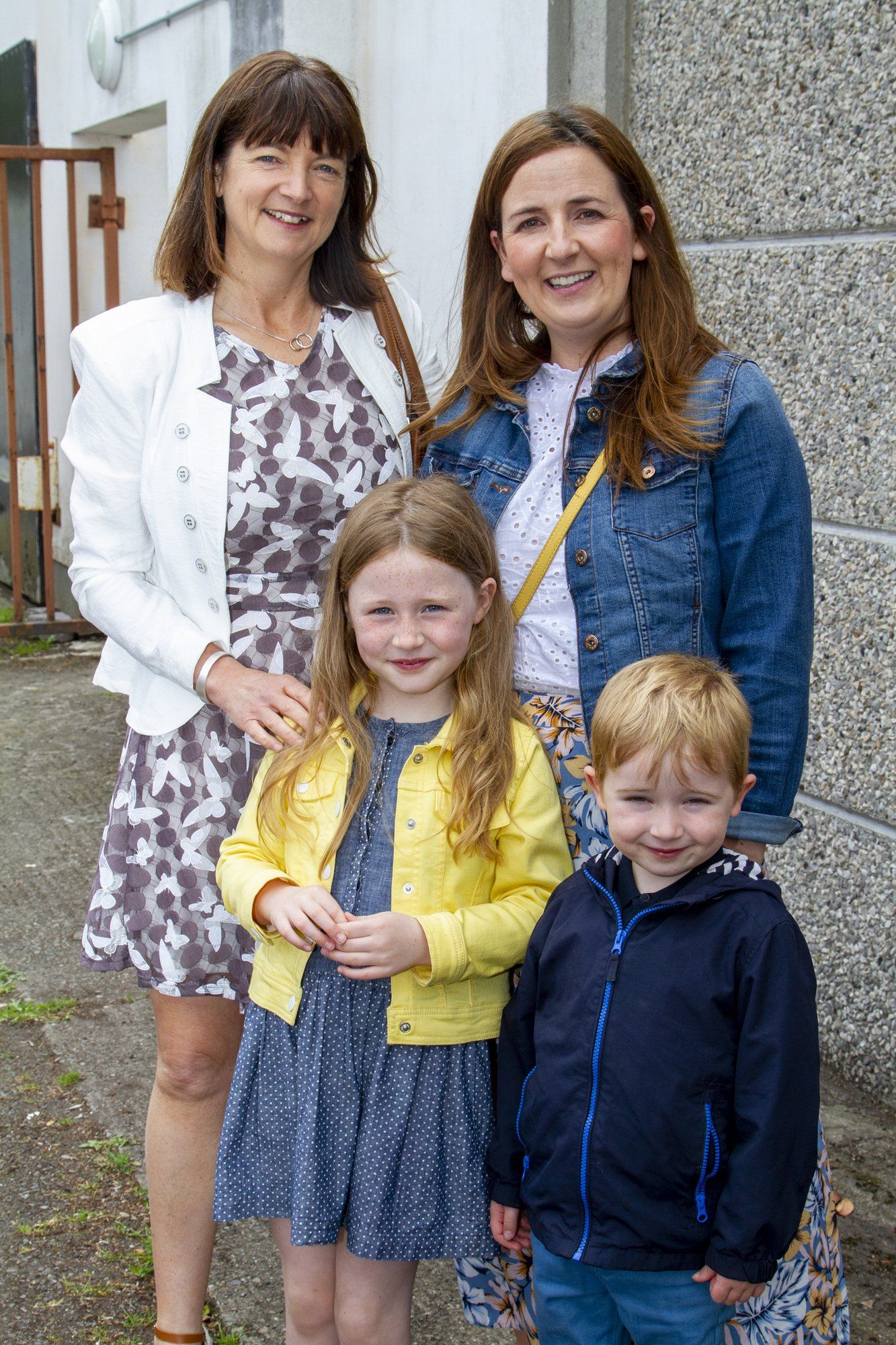 Three women and two children are posing for a picture.