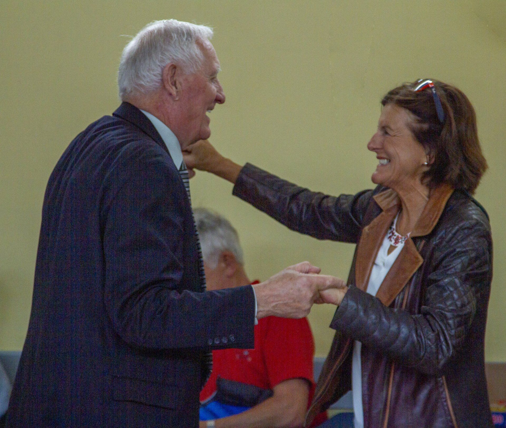 A man and a woman are holding hands and smiling