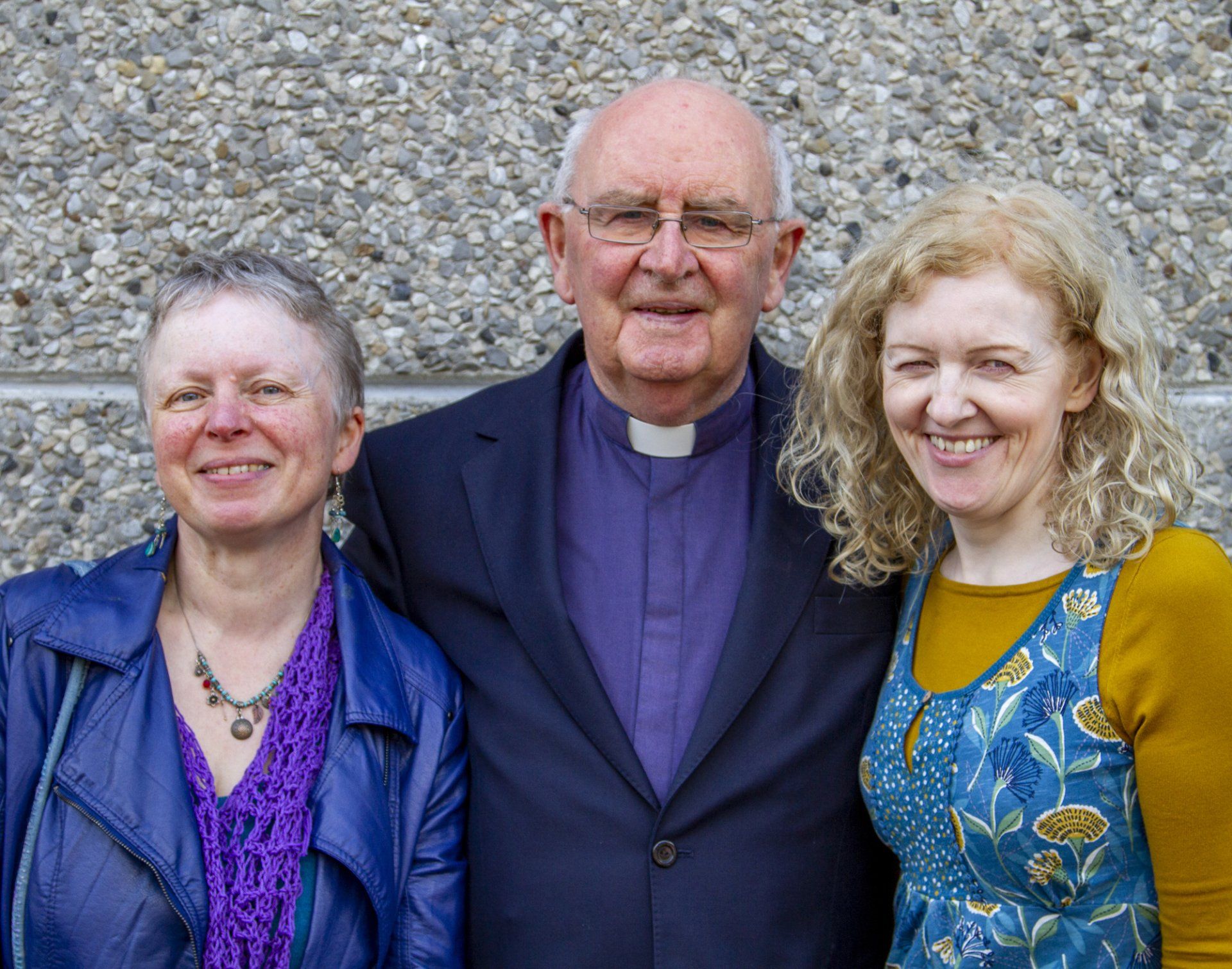 A man and two women are posing for a picture together.