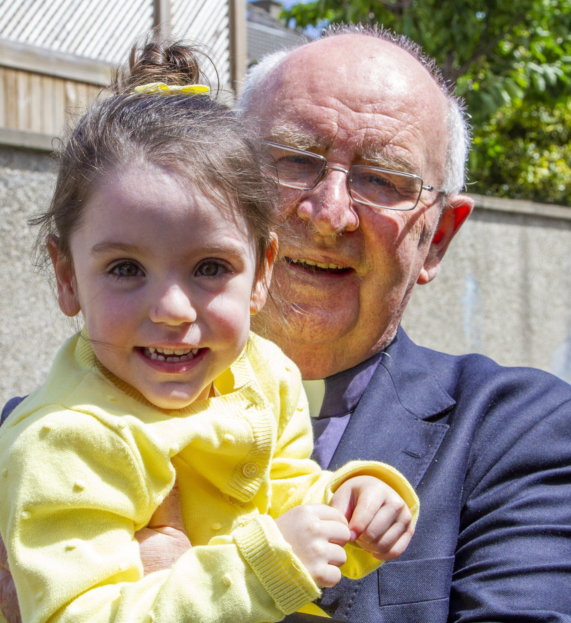 A man in a suit is holding a little girl in his arms