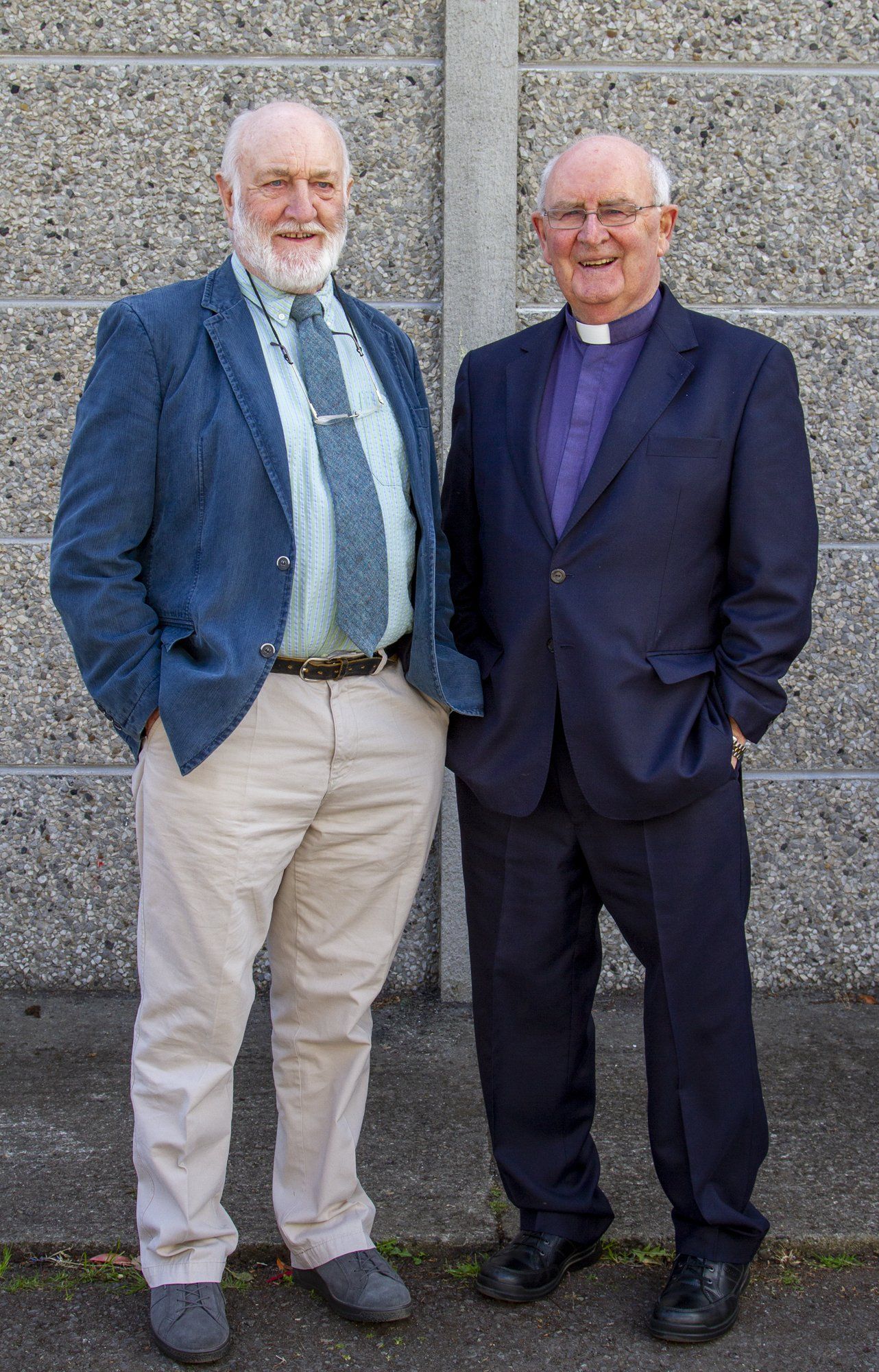Two men in suits and ties are standing next to each other.