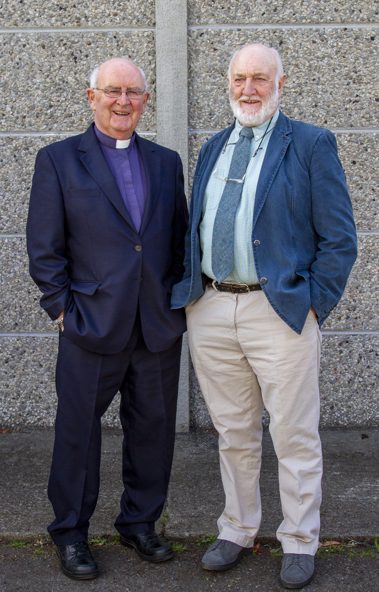 Two men in suits and ties are standing next to each other.