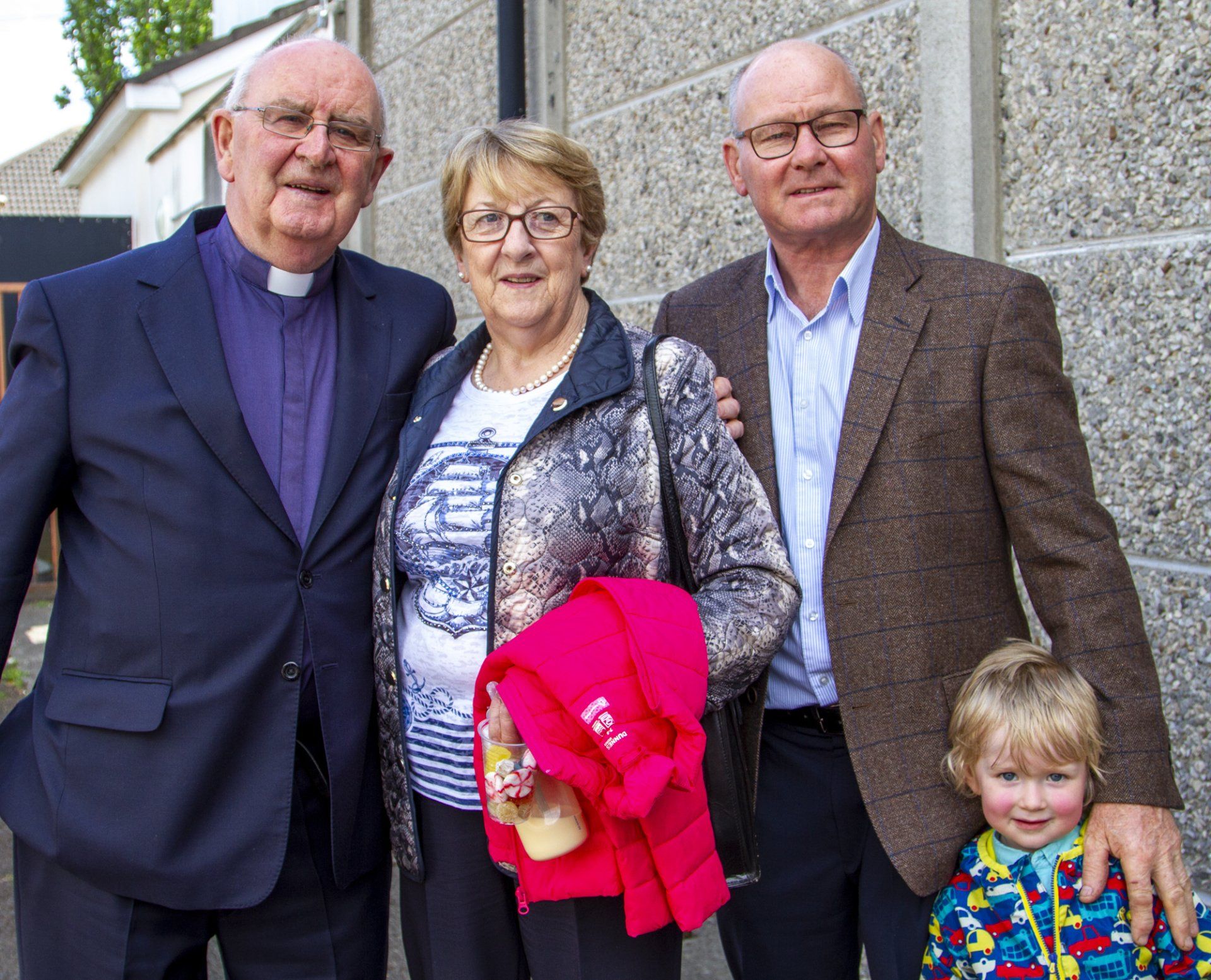 A group of people standing next to each other in front of a building.