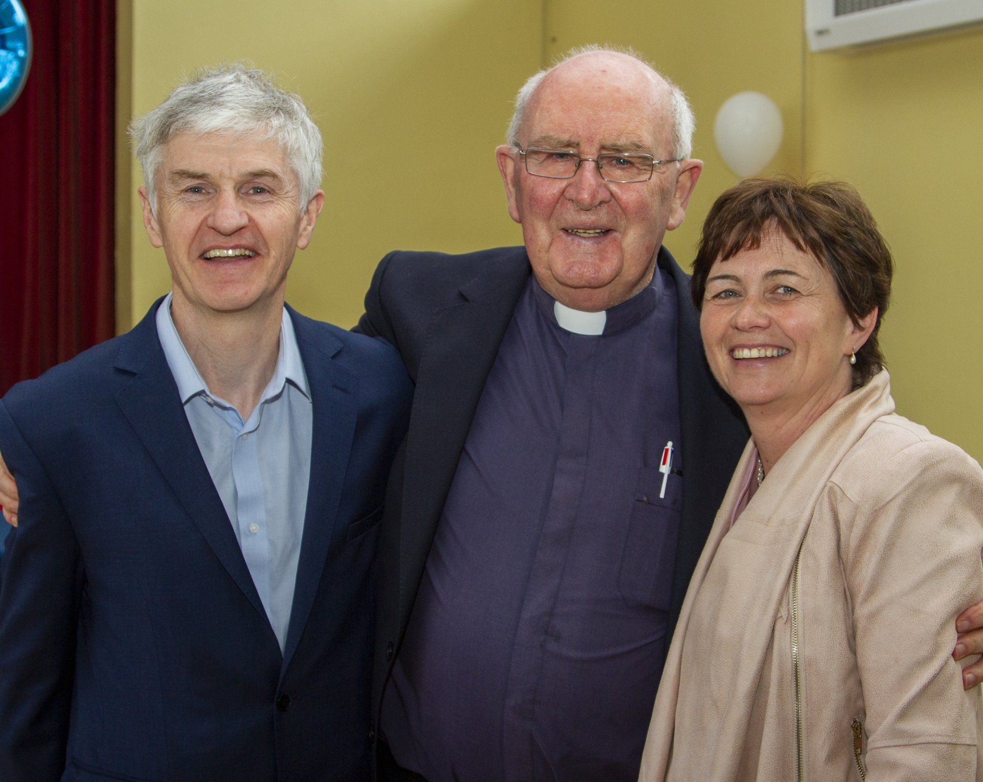 Two men and a woman are posing for a picture together.