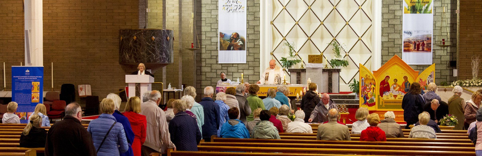 A large group of people are standing in a church.