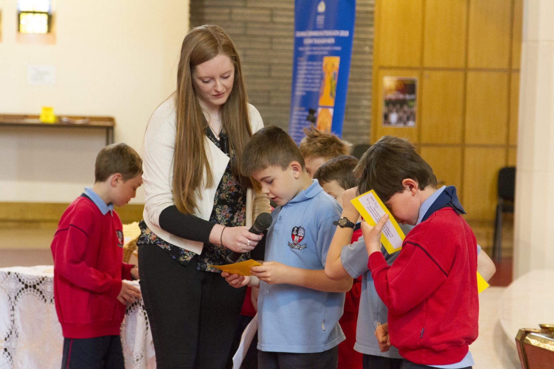 A woman is standing next to a group of children.