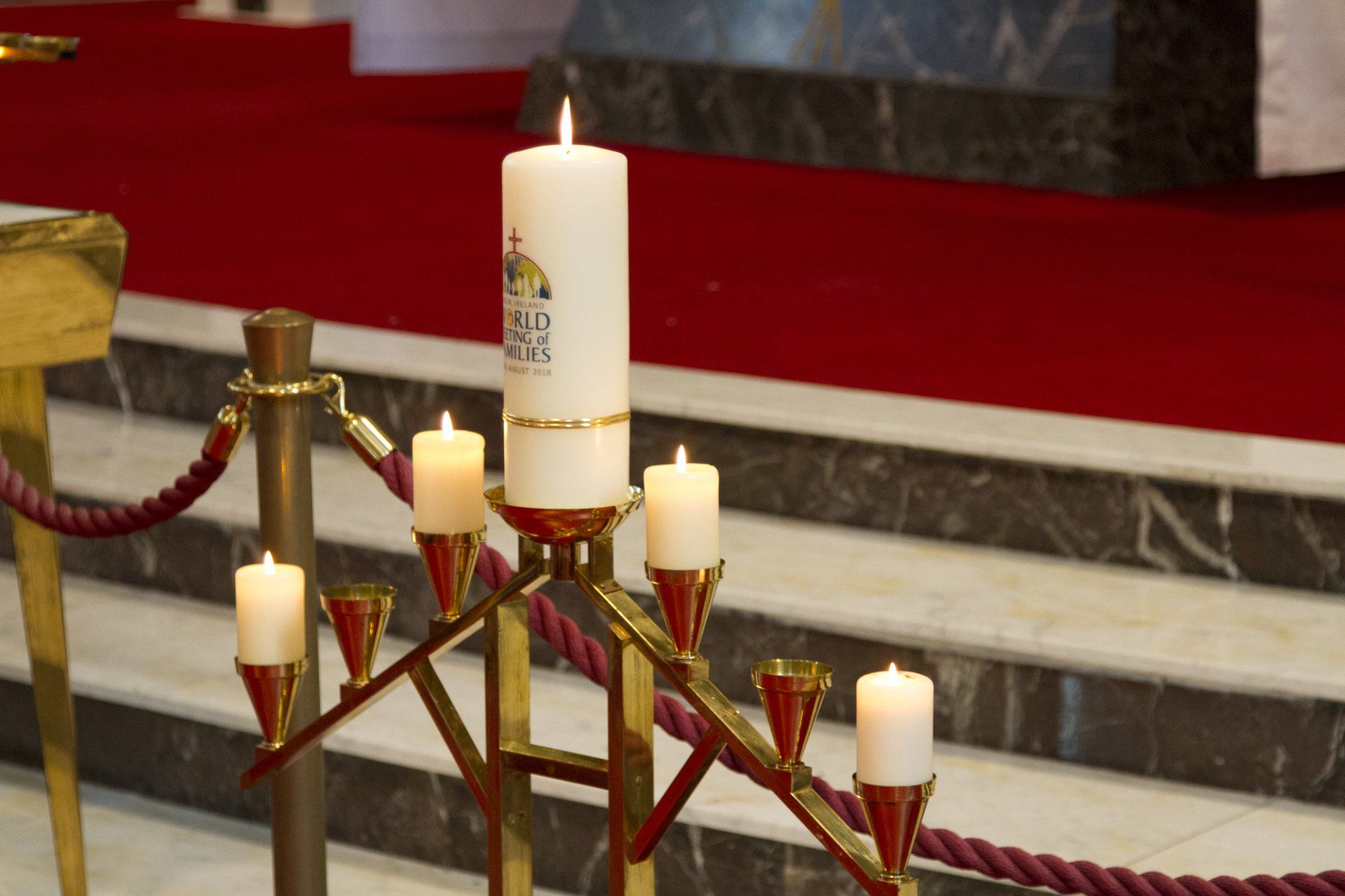 A white candle with the word jesus on it