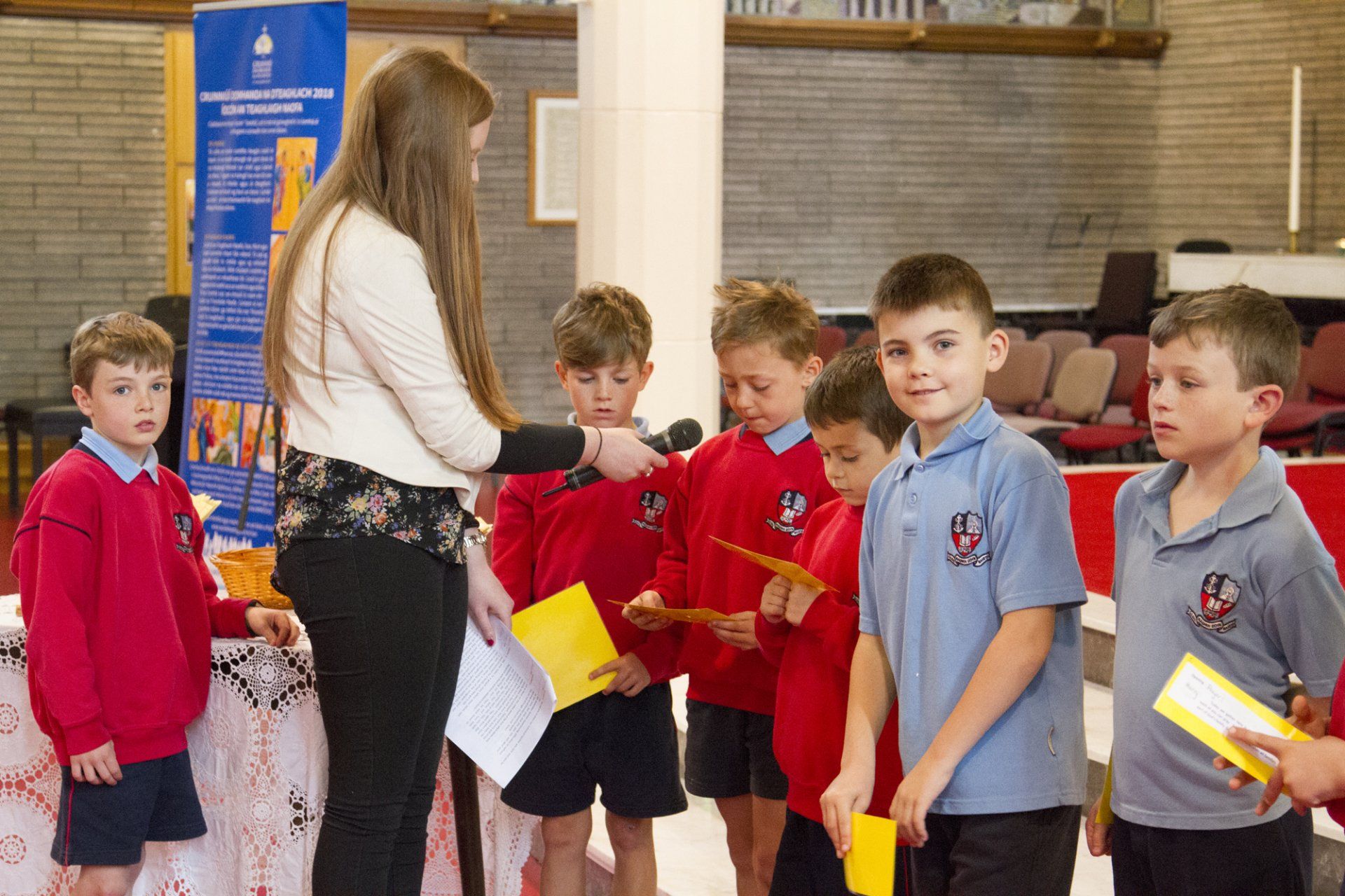A woman is giving a certificate to a group of children