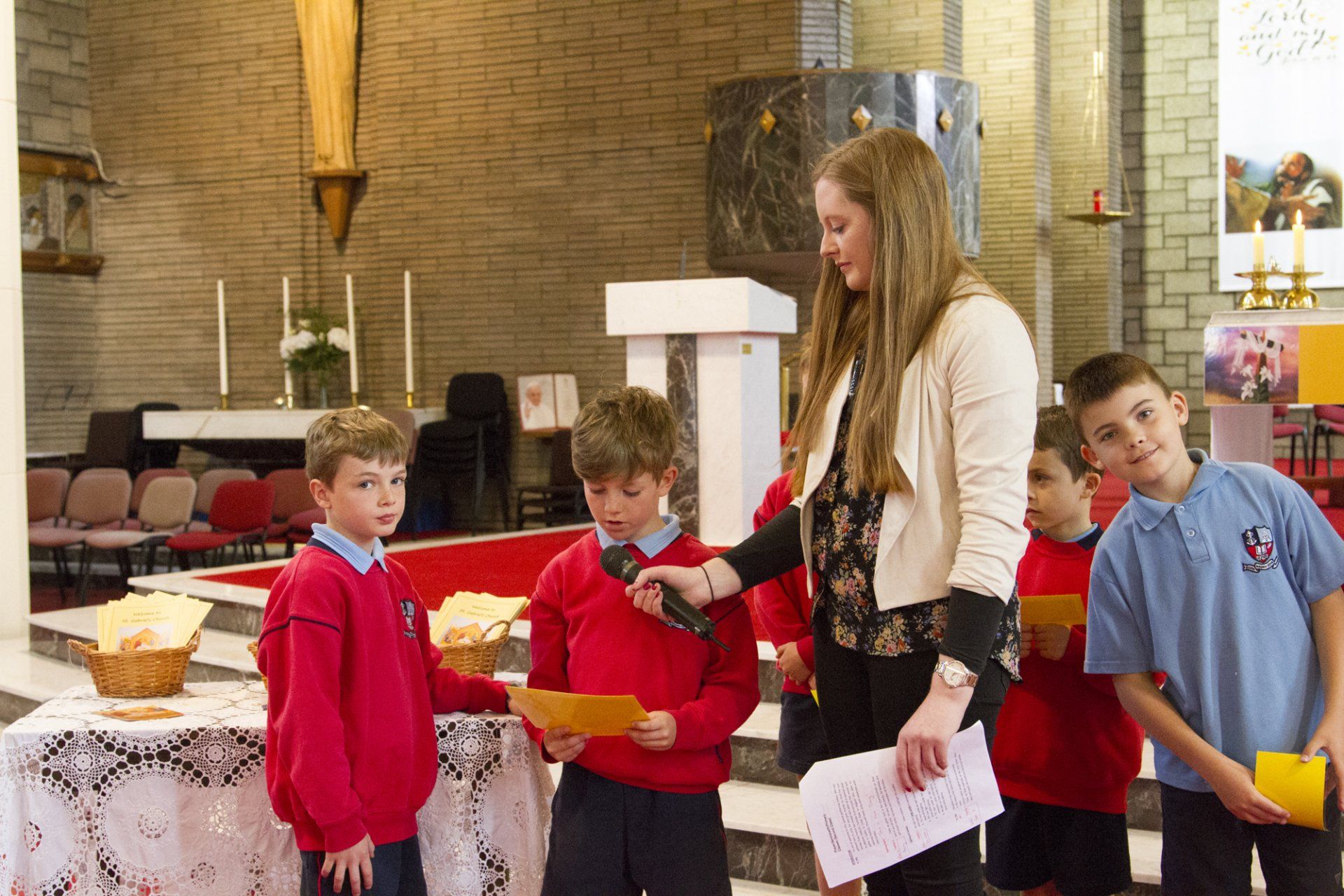 A woman is giving a presentation to a group of children in a church.