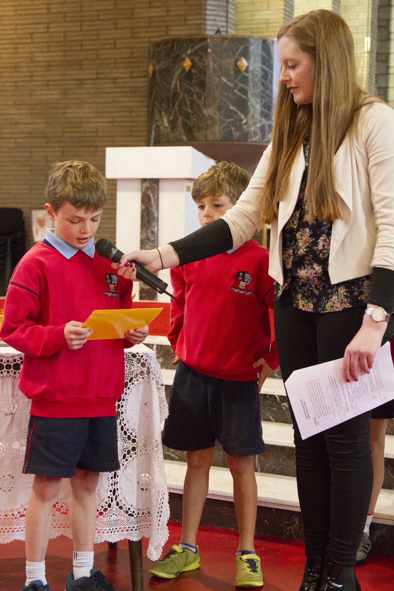 A woman is giving a presentation to two young boys.
