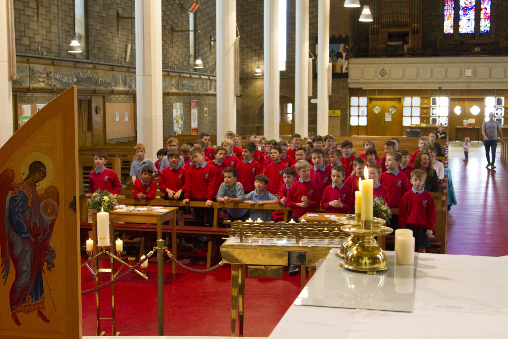 A group of children are sitting at a table in a church.