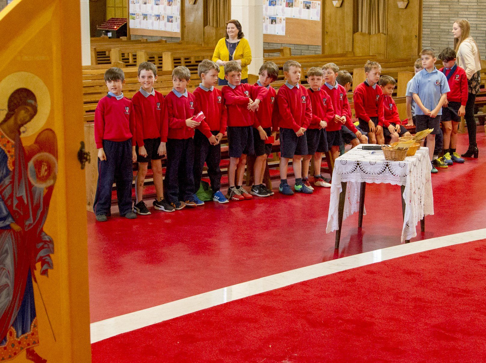 A group of children are standing in front of a table in a church.