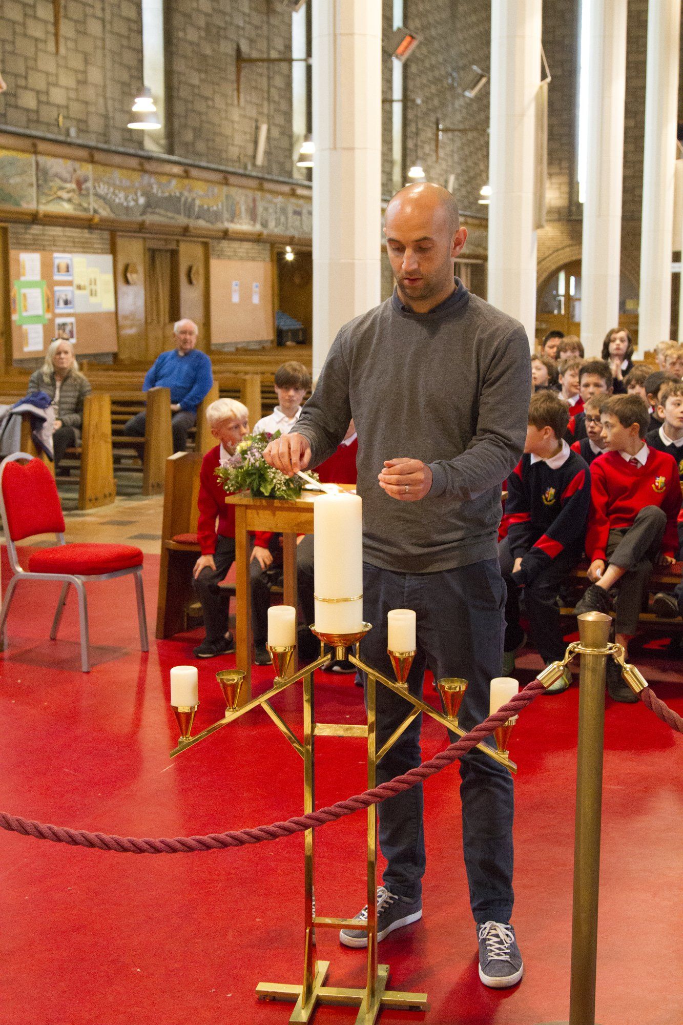 A man is lighting a candle in a church.
