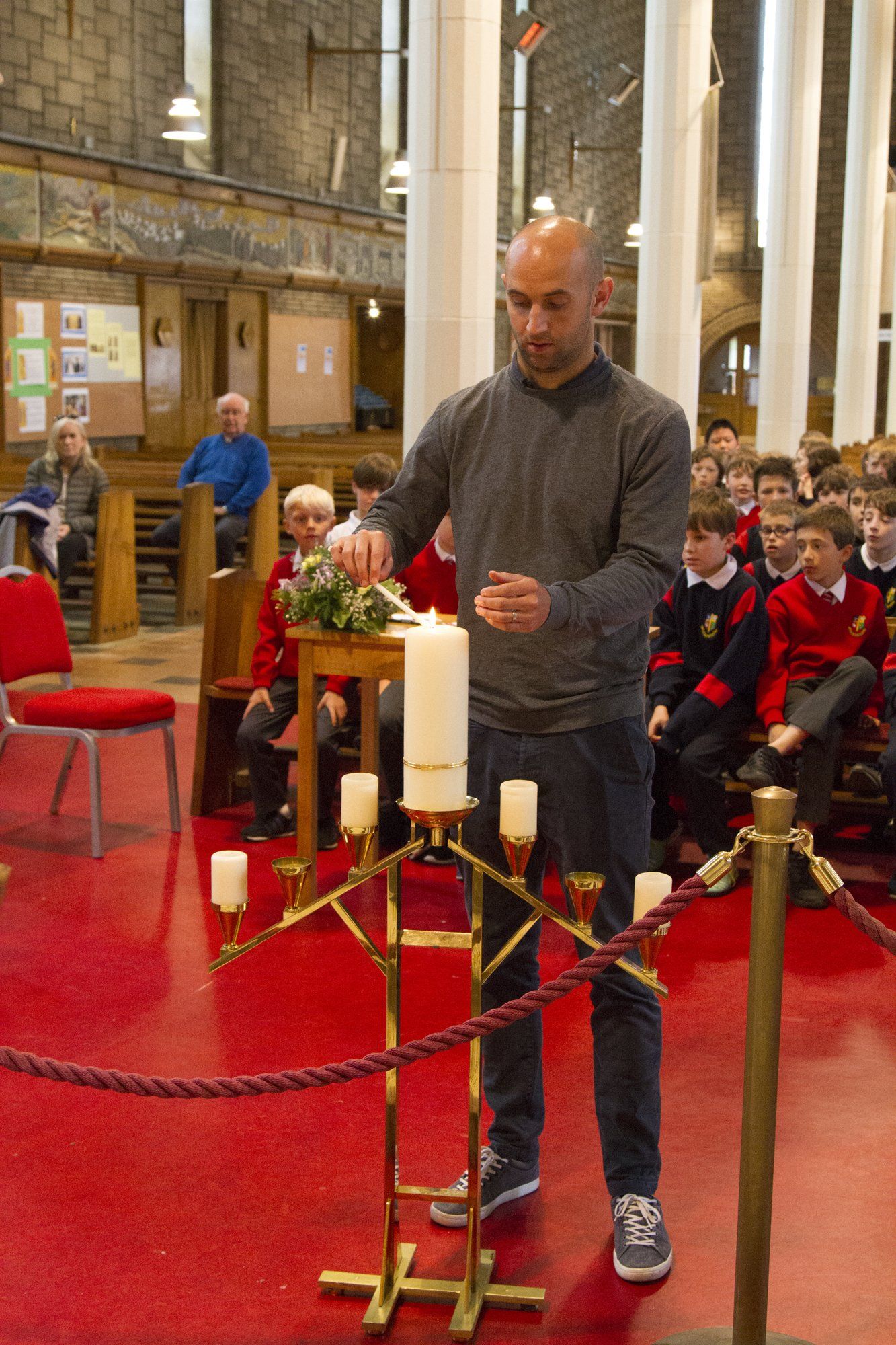 A man is lighting a candle in a church