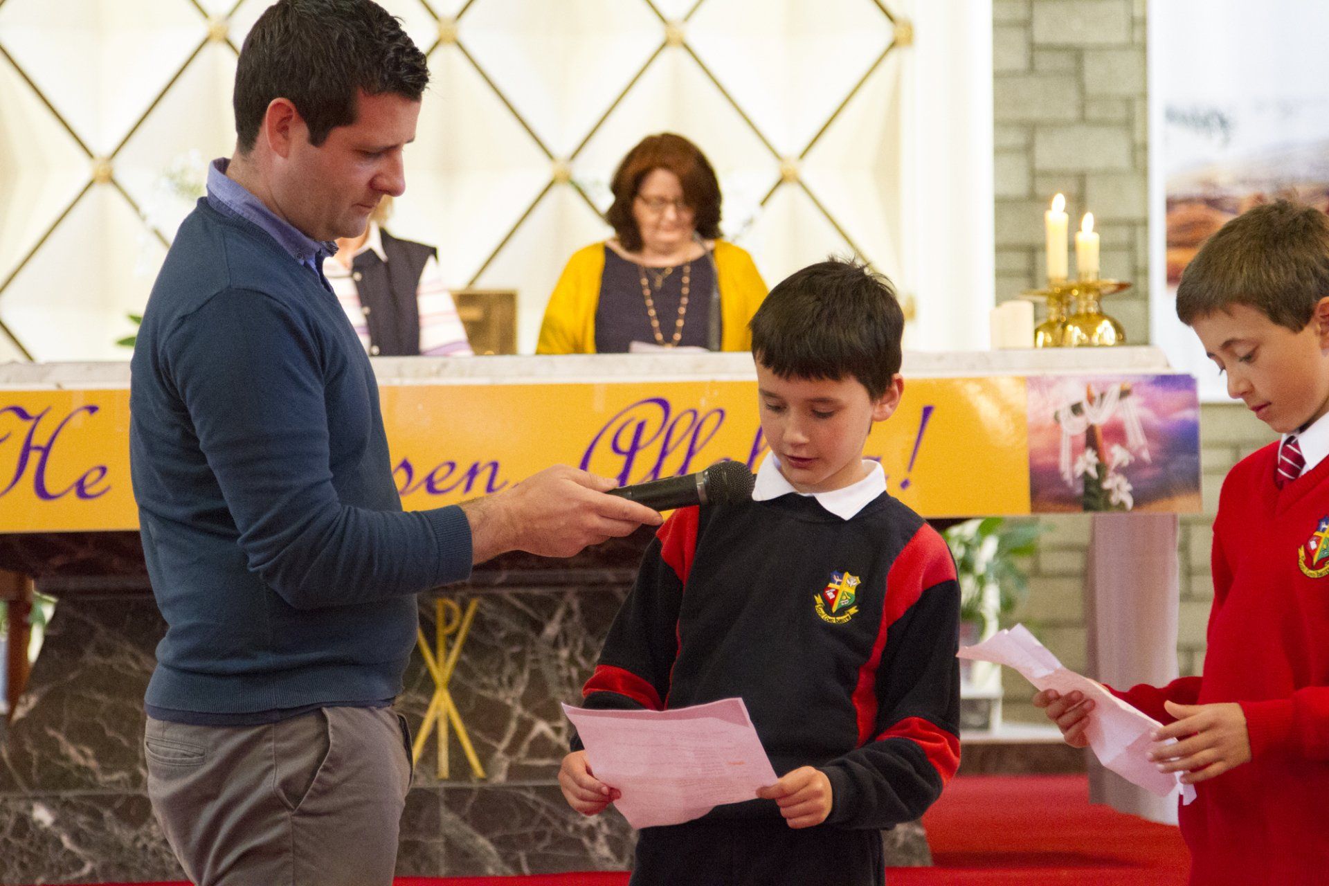 A man is talking to two young boys in a church