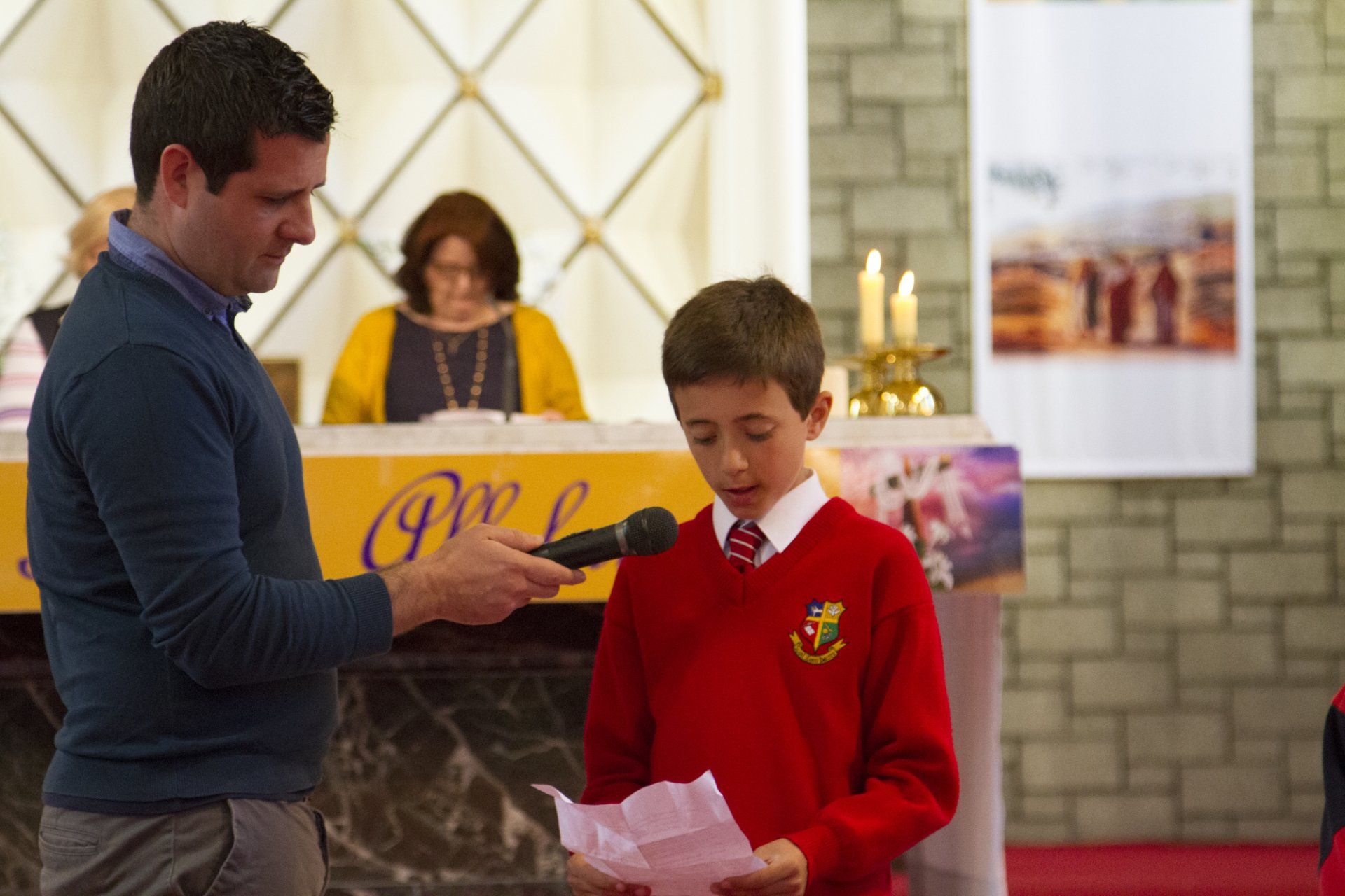 A man is giving a speech to a young boy in a church.