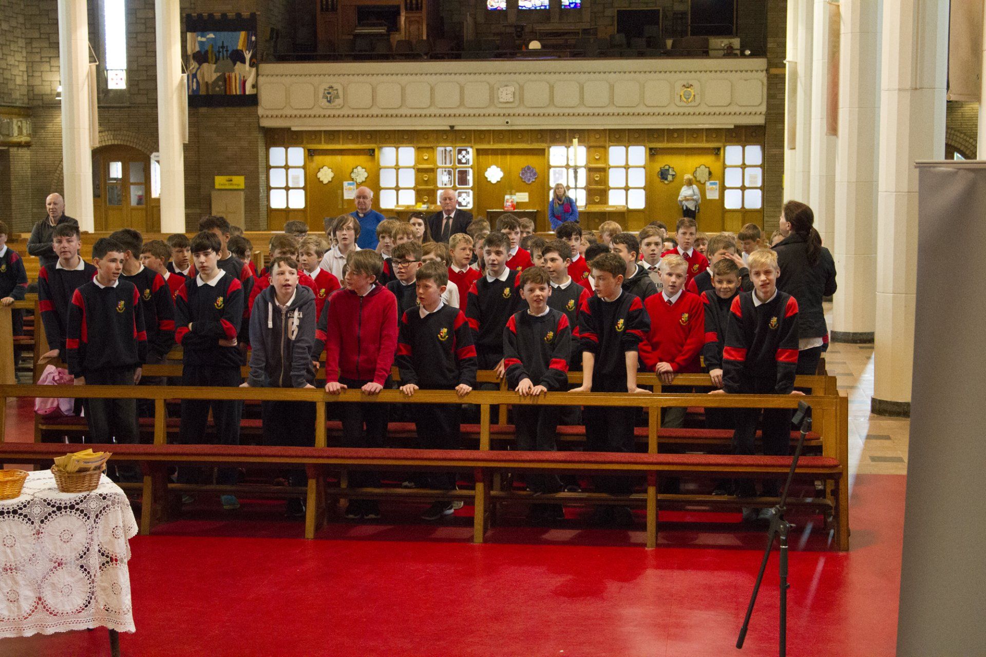 A large group of children are sitting on benches in a church