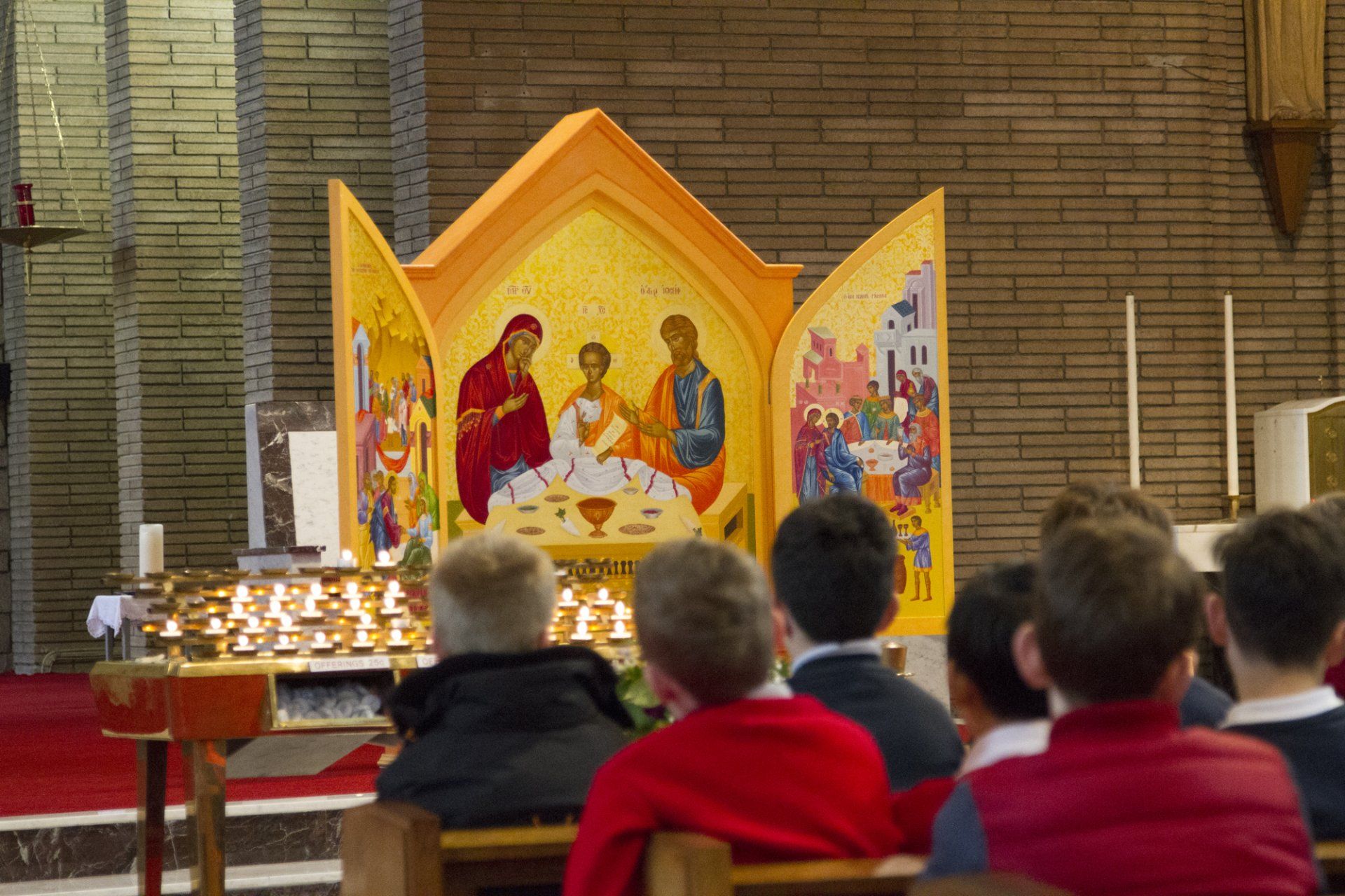A group of children are sitting in front of an altar in a church.