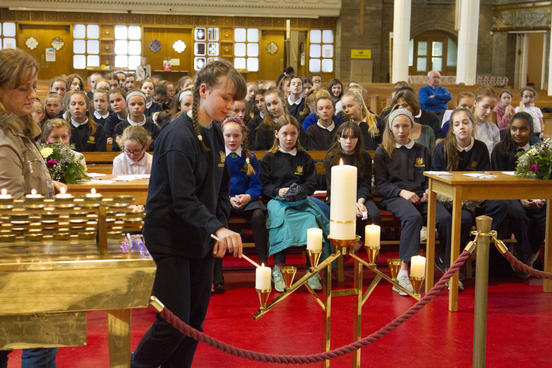 A girl is lighting a candle in a church
