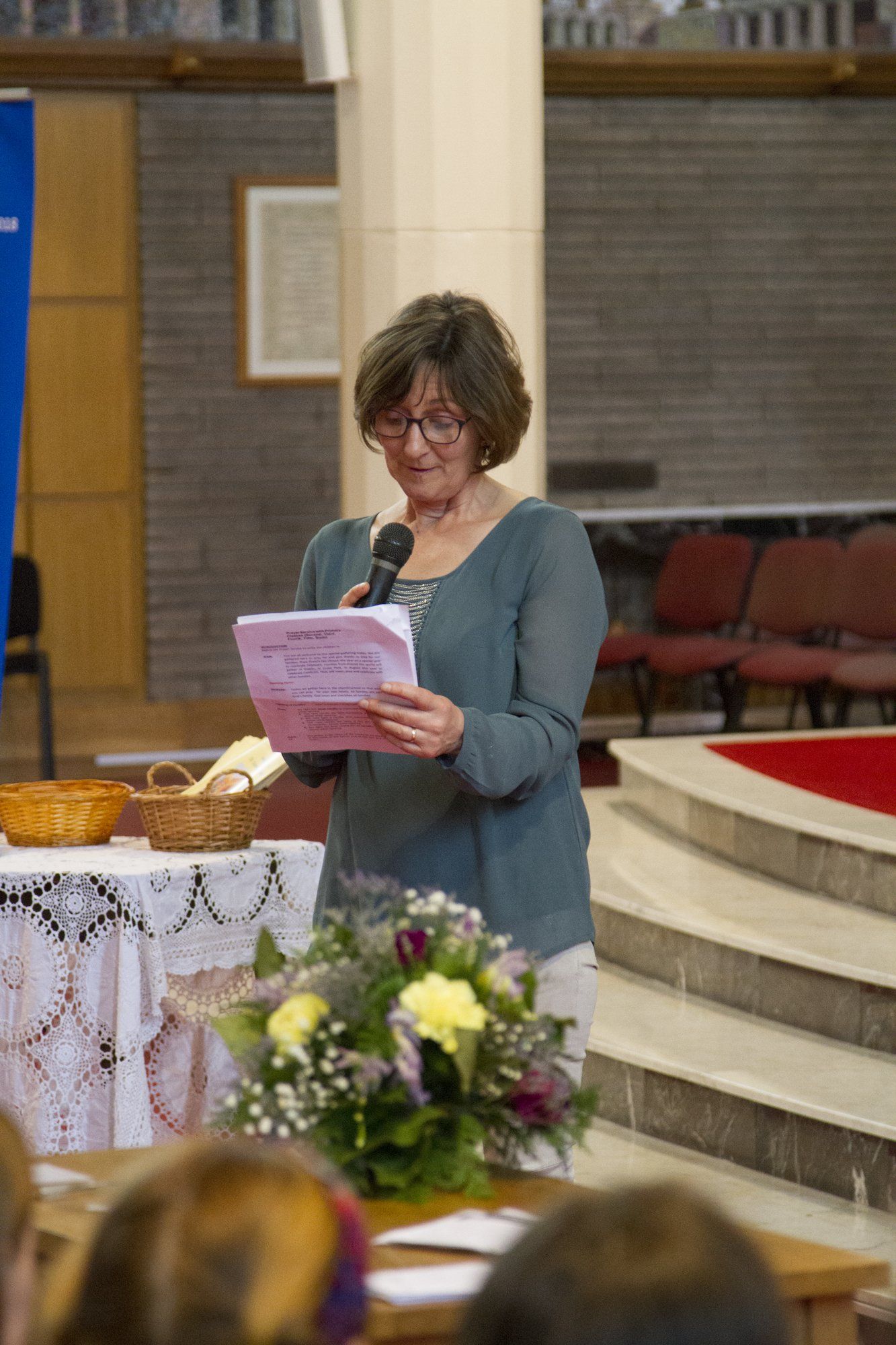 A woman is giving a speech in a church while holding a microphone.