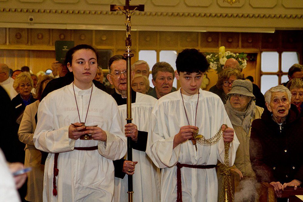 A group of priests carrying a cross in a church