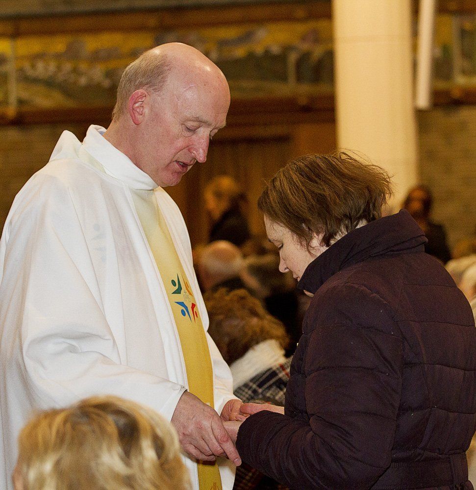 A man in a white robe with a yellow sash that says ' jesus ' on it