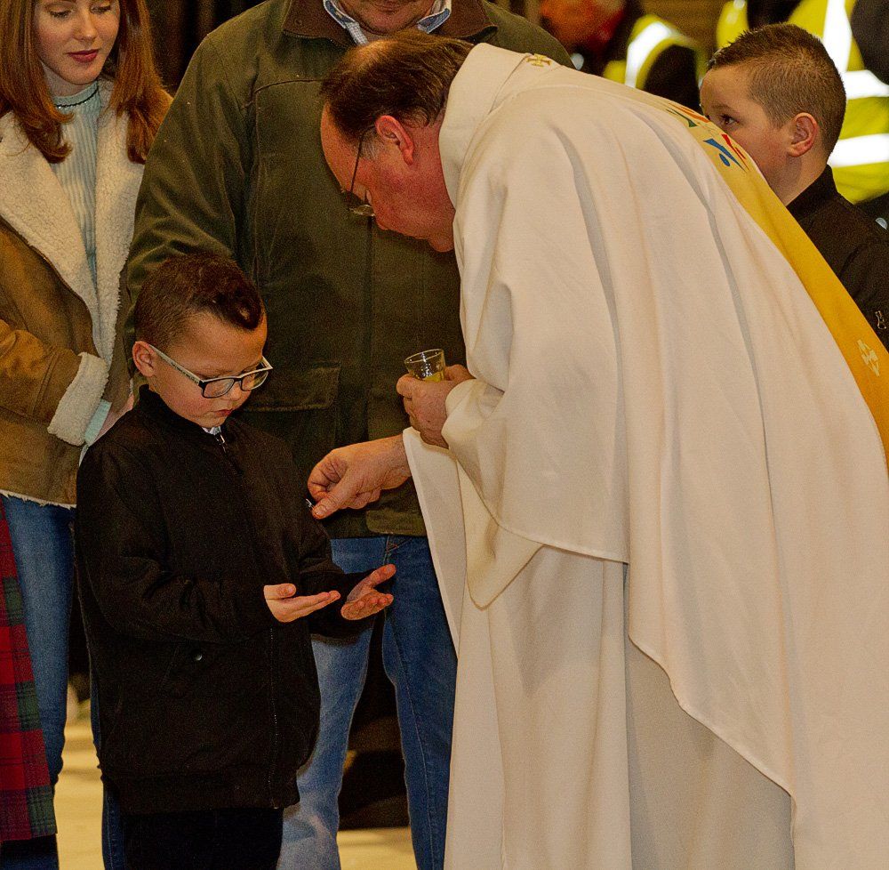 A man in a white robe is talking to a young boy