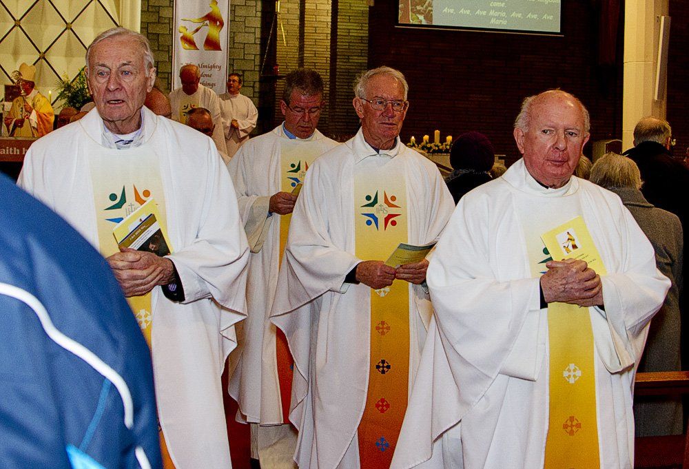 A group of priests are walking in a church
