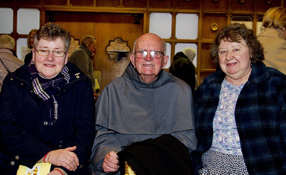 A man and two women are posing for a picture together