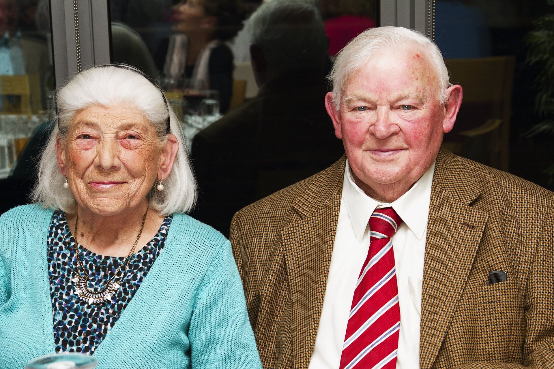 A man and a woman are sitting next to each other and smiling for the camera.