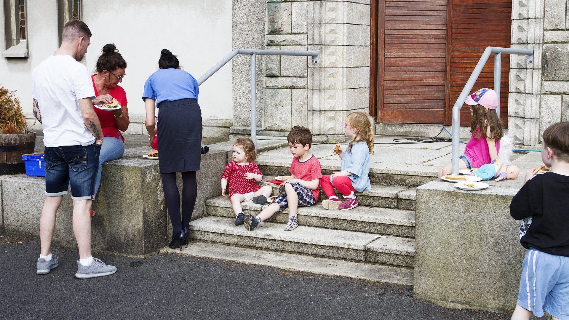 A group of children are sitting on the steps of a building.