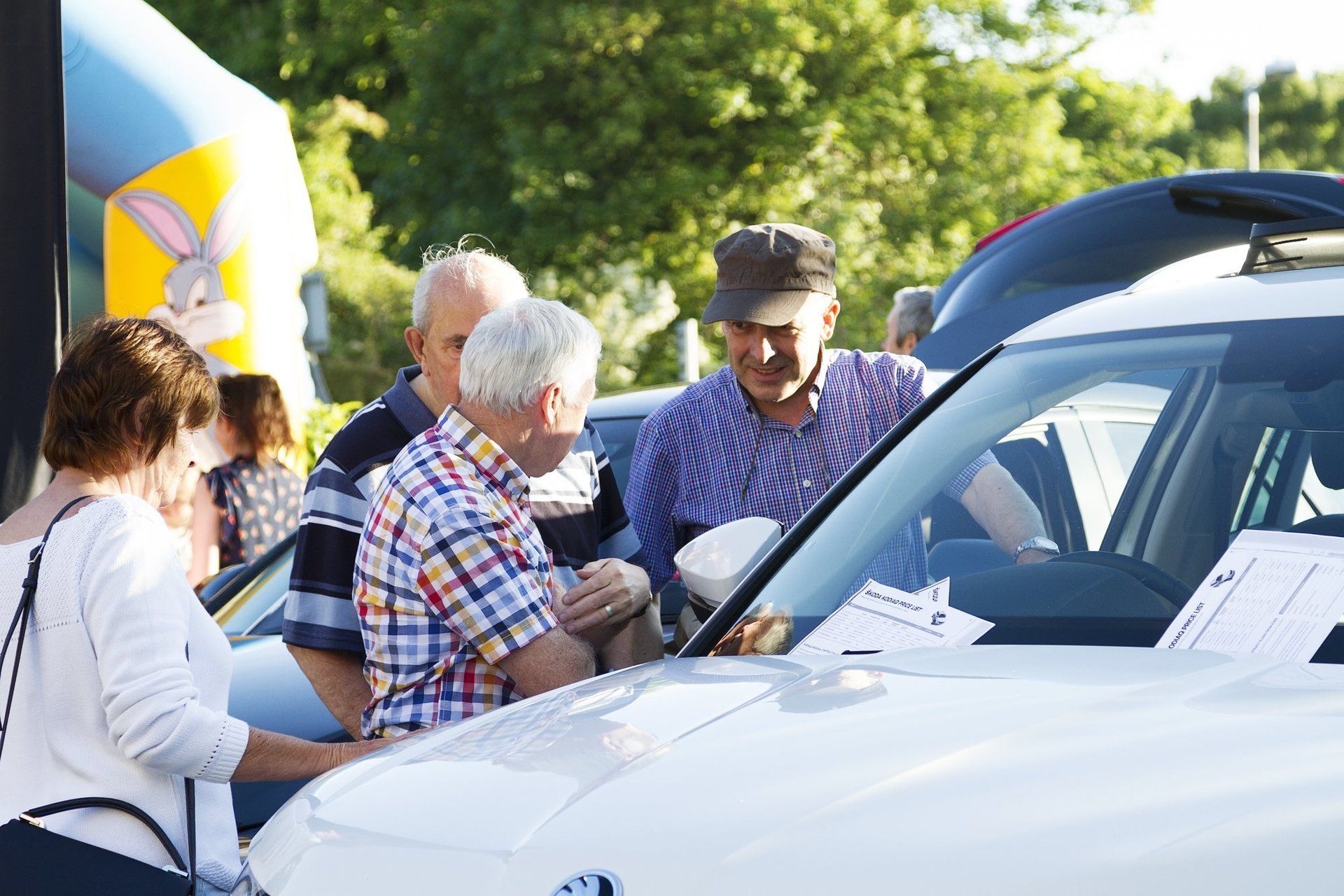 A group of people are looking at a car at a car show.