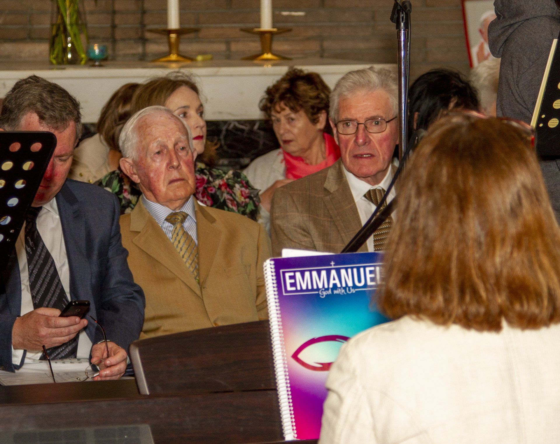 A group of people sitting in front of a book titled emmanuel