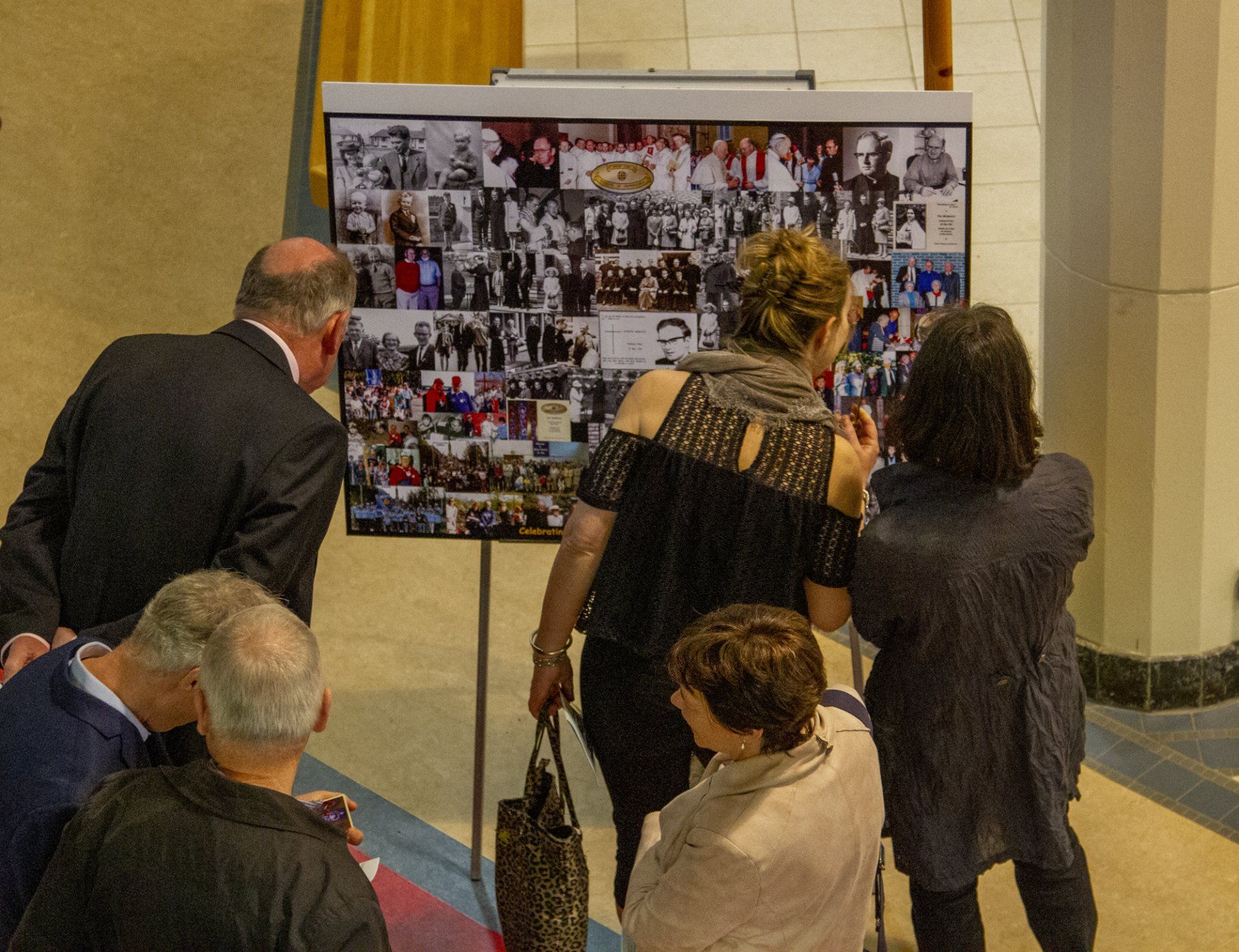 A group of people are looking at a collage of pictures