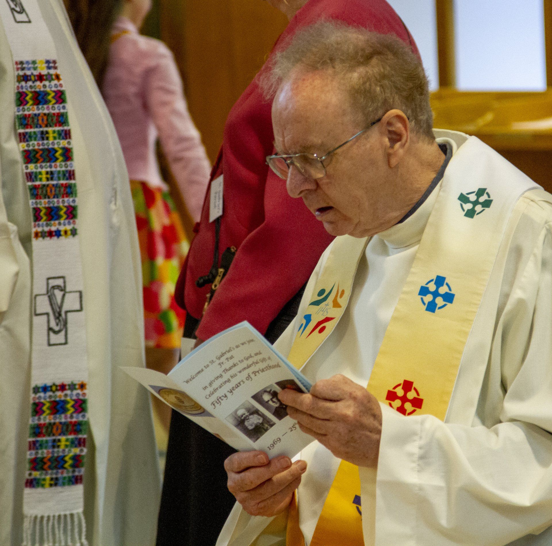 A man in a white robe is reading a book