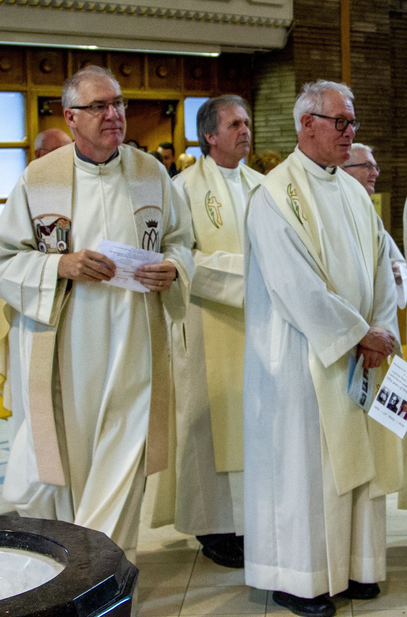 A group of priests are standing in a church.