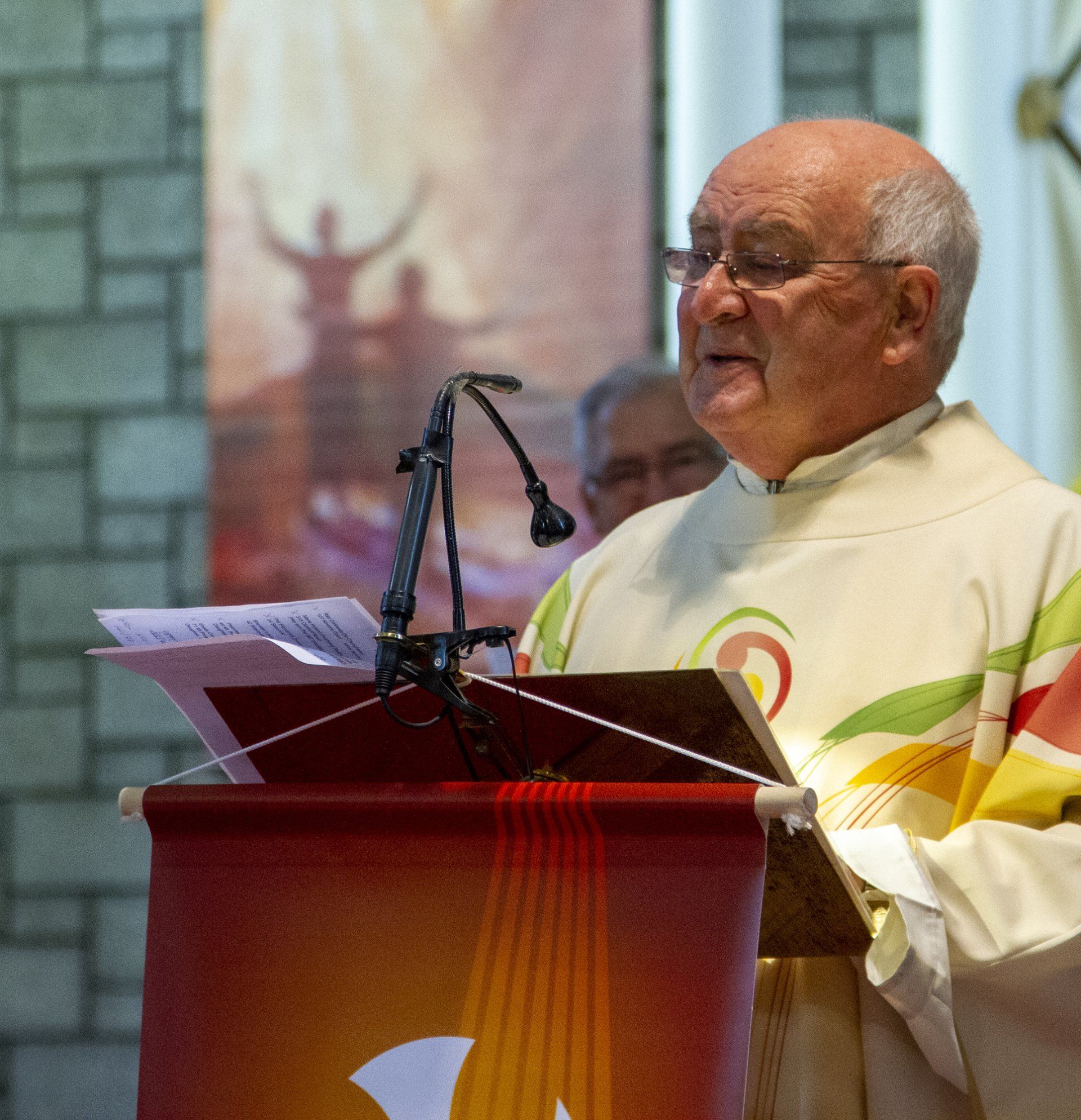 A man is standing at a podium with a microphone in front of him