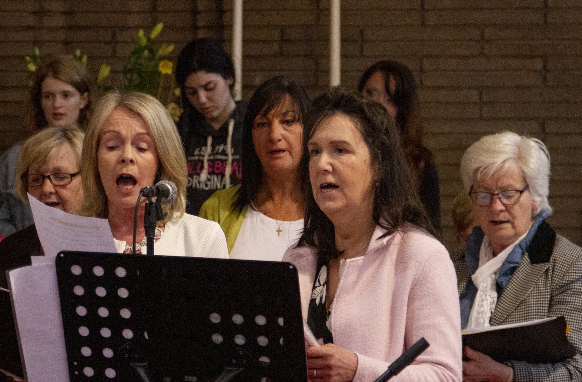 A group of women are singing in a church choir.