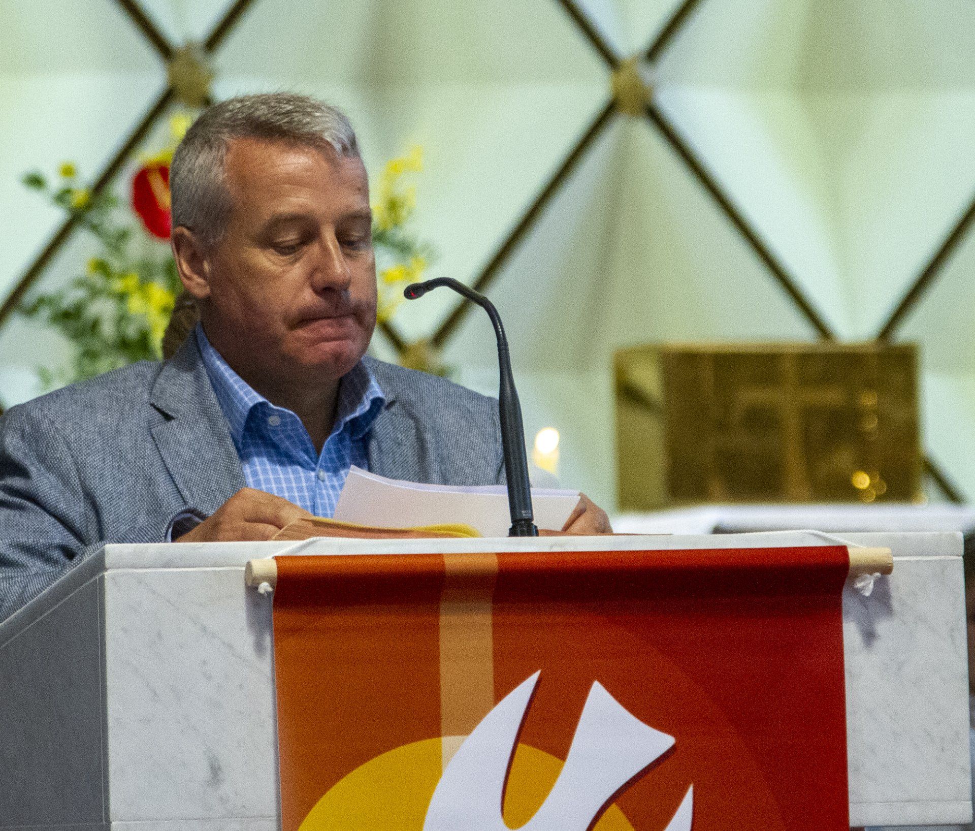 A man stands behind a podium with a dove on it
