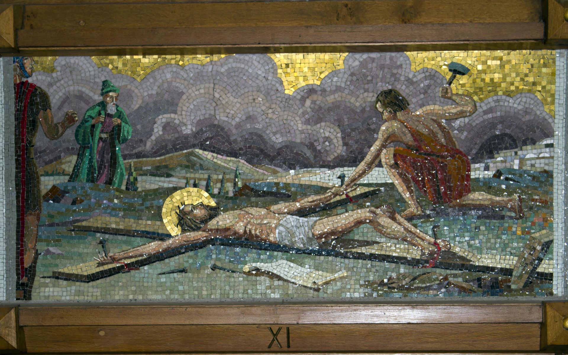 A mosaic painting of jesus laying on the cross.
