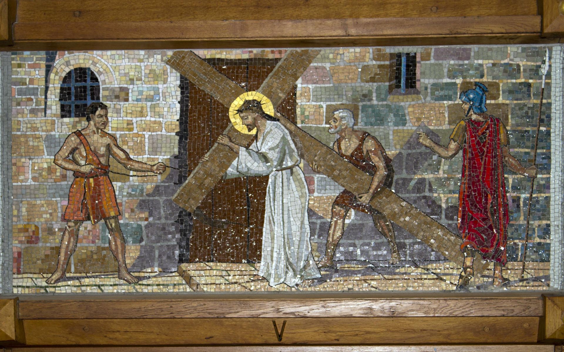 A mosaic painting of jesus carrying a cross.