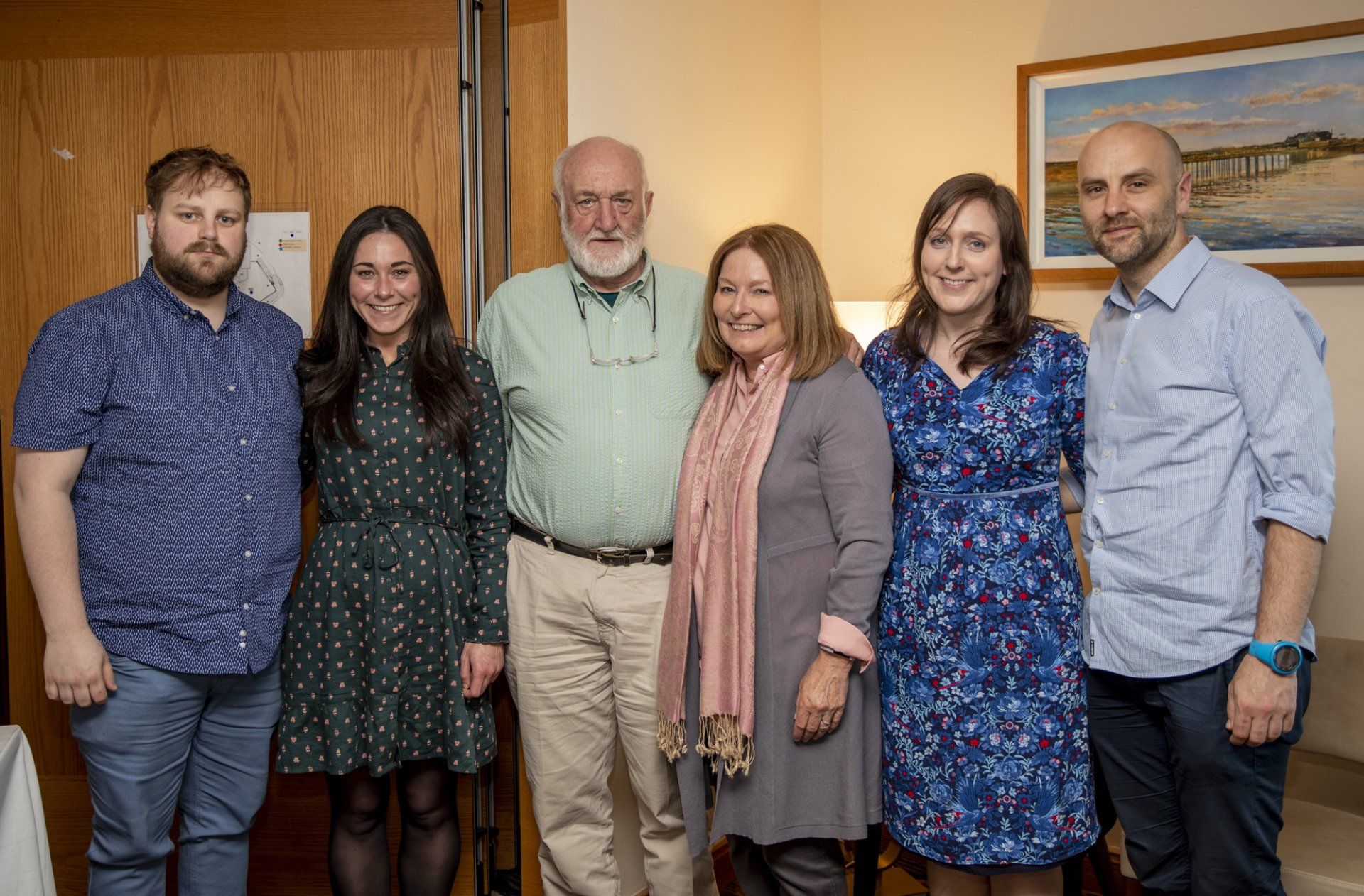 A group of people are posing for a picture together in a room.