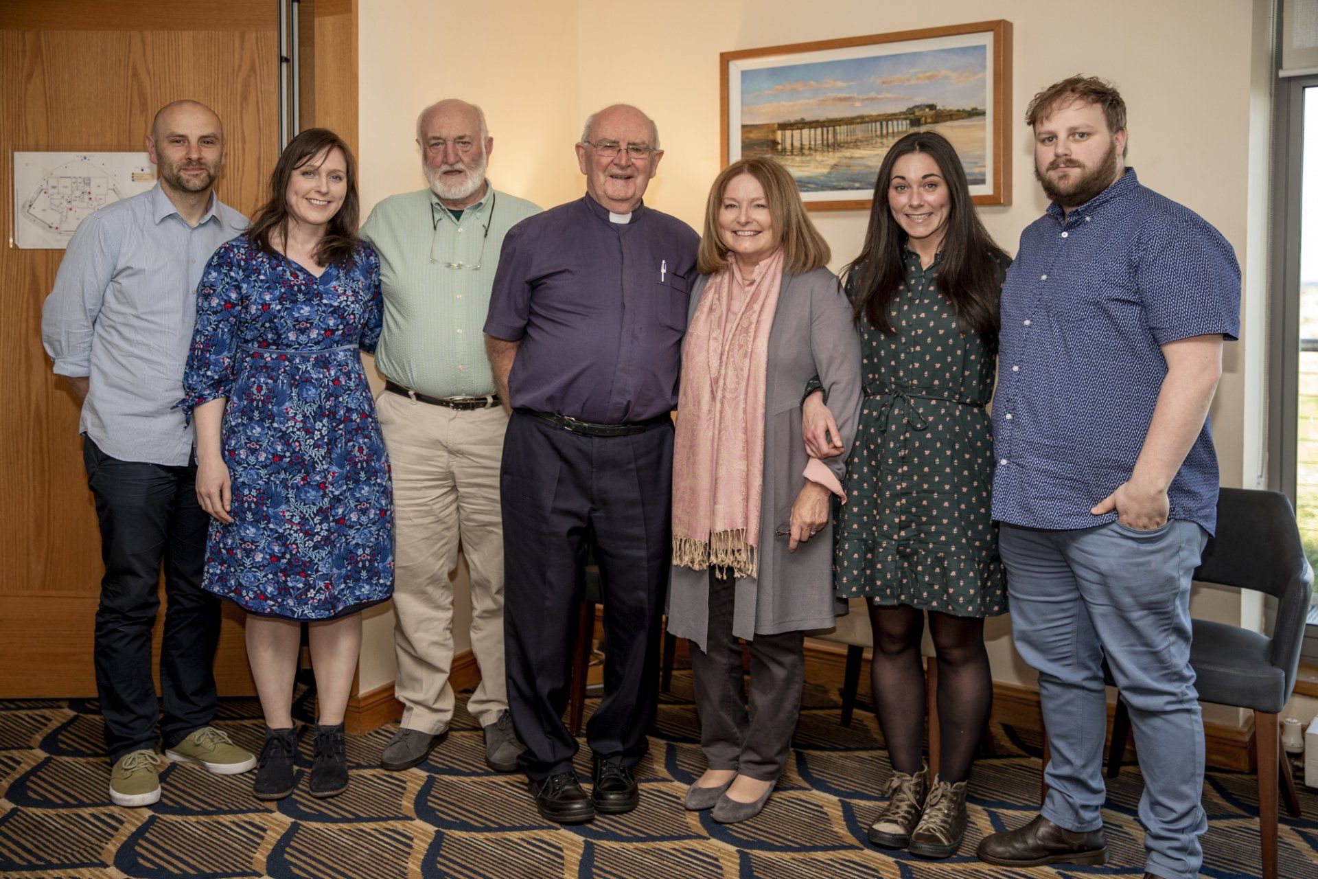 A group of people are posing for a picture together in a room.